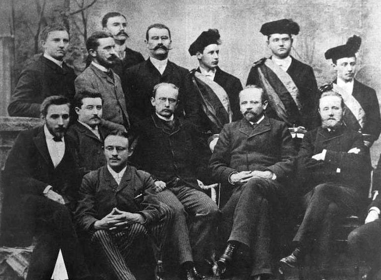 Bild von 1889 mit Luigi Pirandello und Wendelin Foerster (rechts), darüber die Chargierten des Akademischen Neuphilologischen Vereins zu Bonn